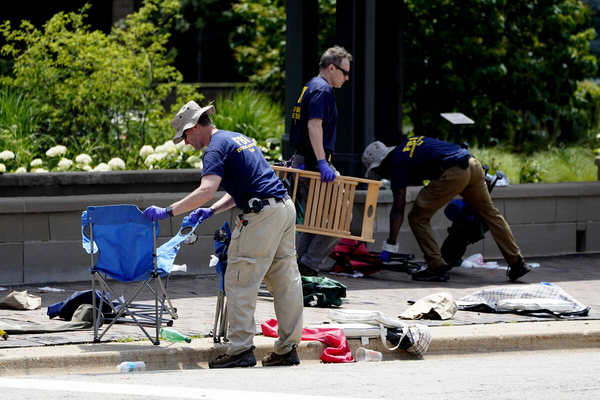Members of the FBI's evidence response team remove personal belongings one day after a mass sho ...