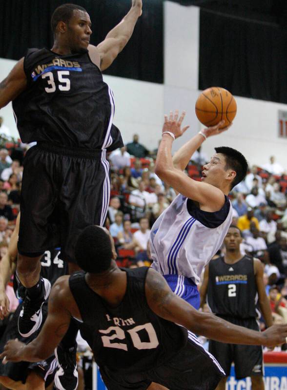 Dallas Mavericks basketball player Jeremy Lin attempts a shot against Washington Wizards player ...