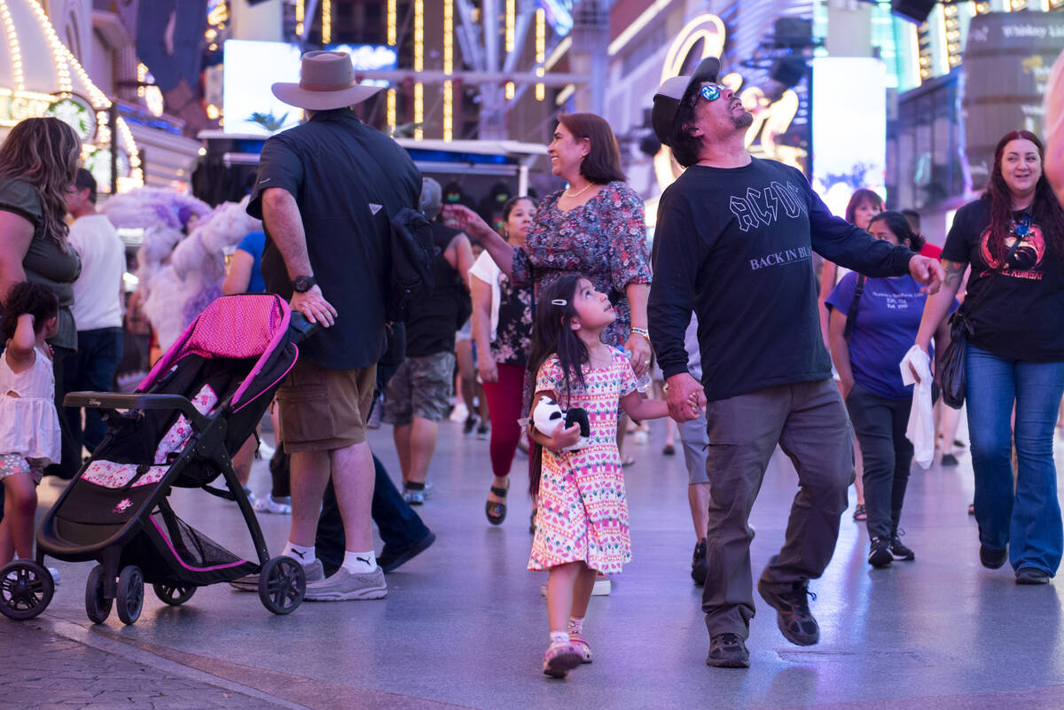 Baola Rodriguez, 5, and her dad Jerry Rodriguez, of California, walk through the Fremont Street ...