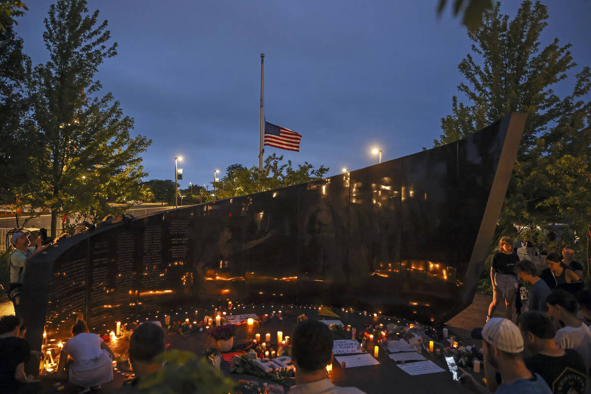 Dozens of mourners gather for a vigil near Central Avenue and St. Johns Avenue in downtown High ...