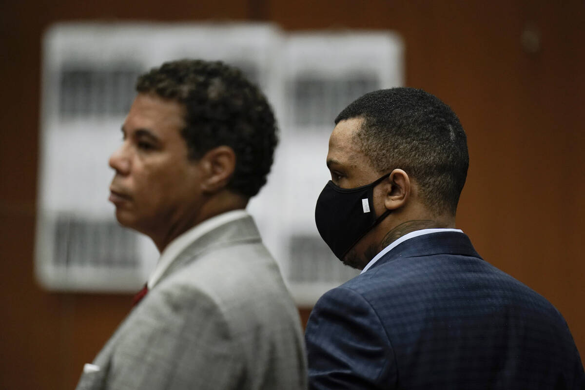 Eric Holder Jr., right, who is accused of killing rapper Nipsey Hussle, and his attorney, Aaron ...