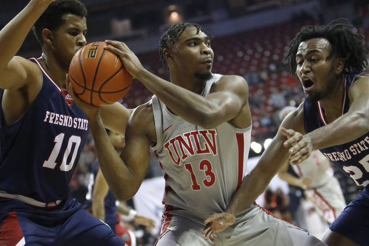 UNLV Rebels guard Bryce Hamilton (13) keeps a ball away from Fresno State Bulldogs forward Orla ...