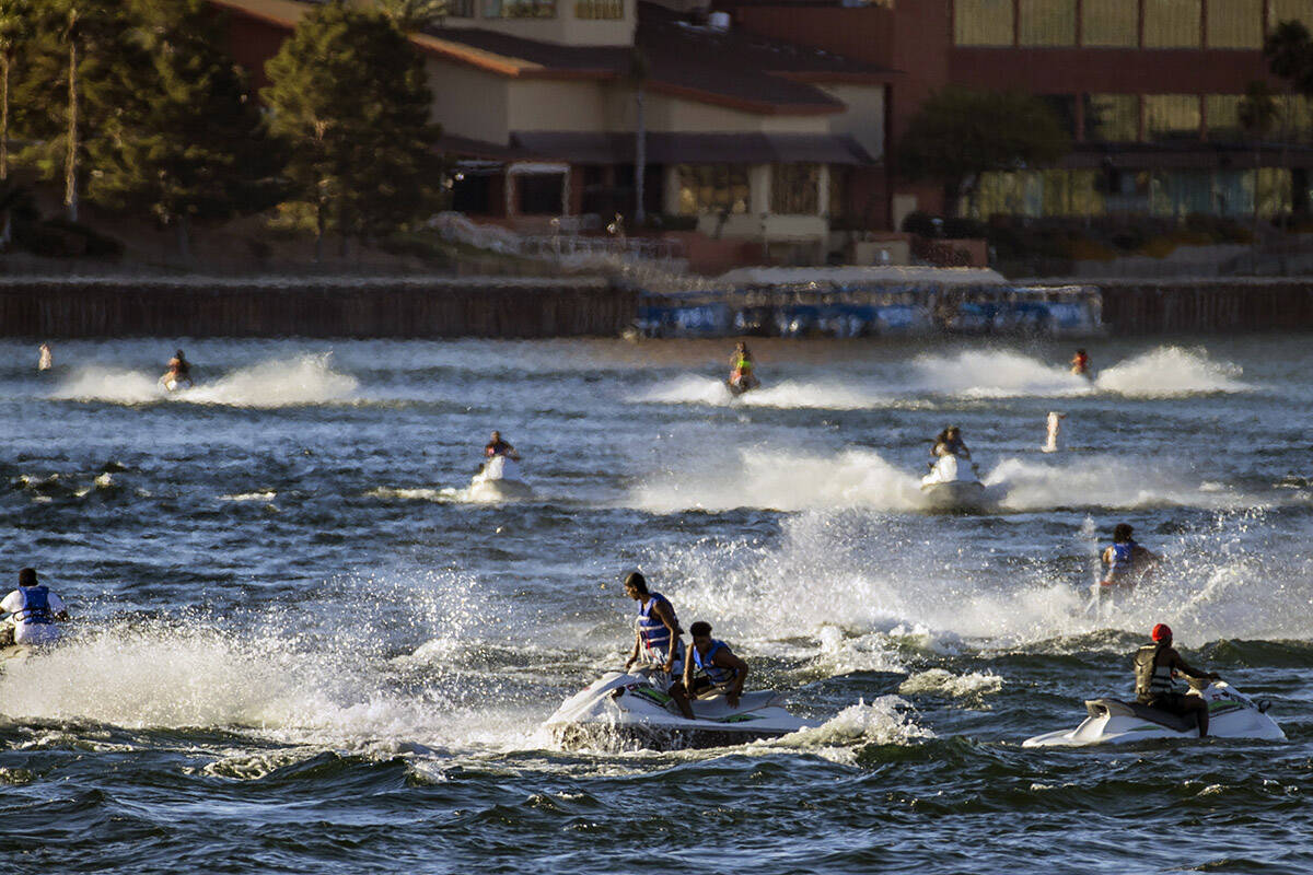 Jetskiers cruise across along the Colorado River near Bullhead City Community Park in May 2020. ...