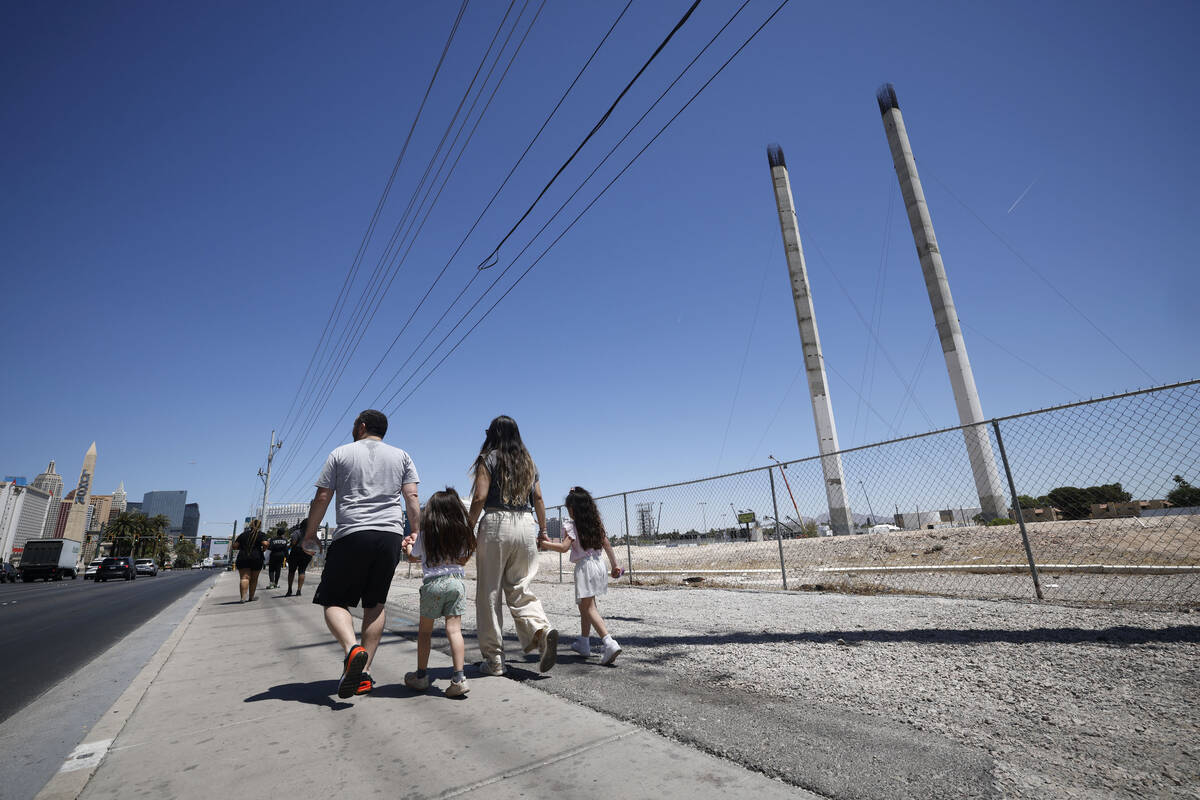 Pedestrians pass by the partially built SkyVue observation-wheel project, Friday, May 13, 2022, ...