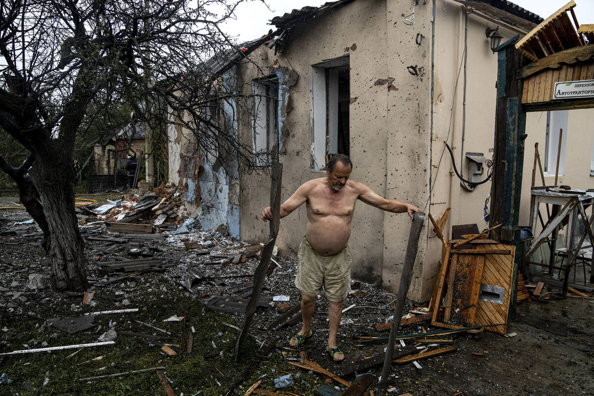 A local man clears rubble from his house which was destroyed after a Russian attack in a reside ...