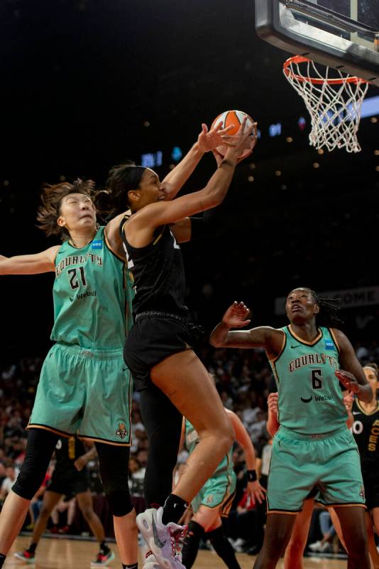 Las Vegas Aces forward A'ja Wilson (22) gets fouled by New York Liberty's Han Xu (21) during th ...