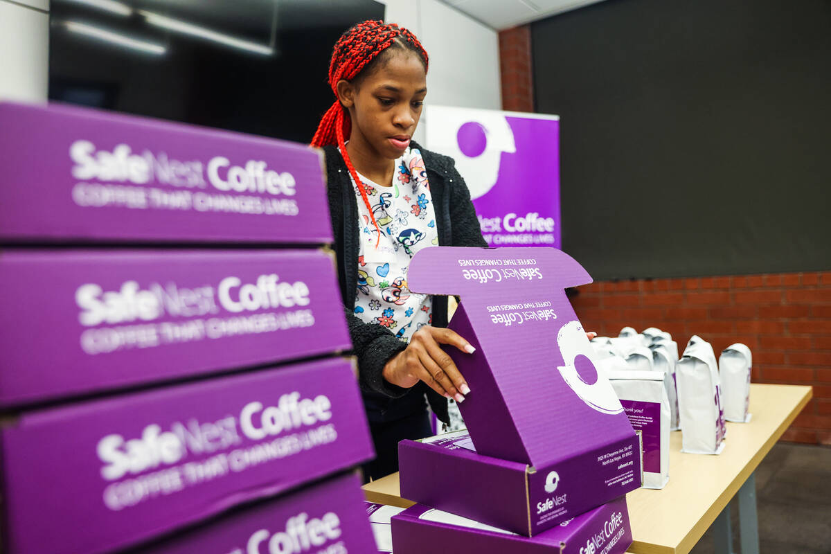 Tyresha packs a box of coffee at SafeNest in Las Vegas, Thursday, July 14, 2022. Tyresha and an ...