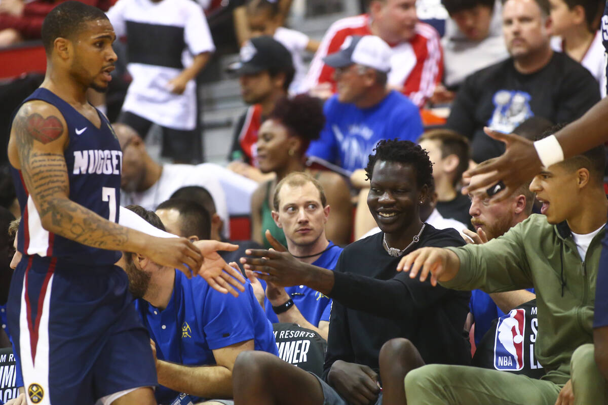 Denver Nuggets' Bol Bol, center, and Michael Porter Jr., right, reach out to high-five teammate ...