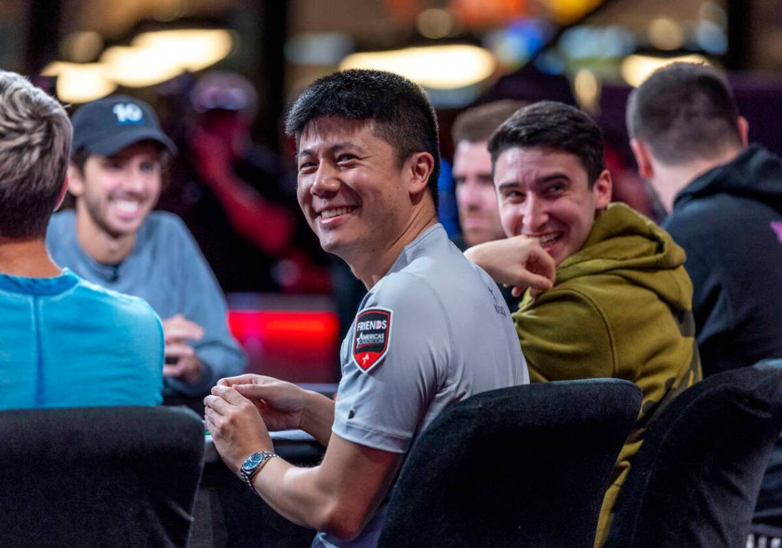 Players Matthew Su, left, and Michael Duek laugh as the crowd chants during final table play at ...