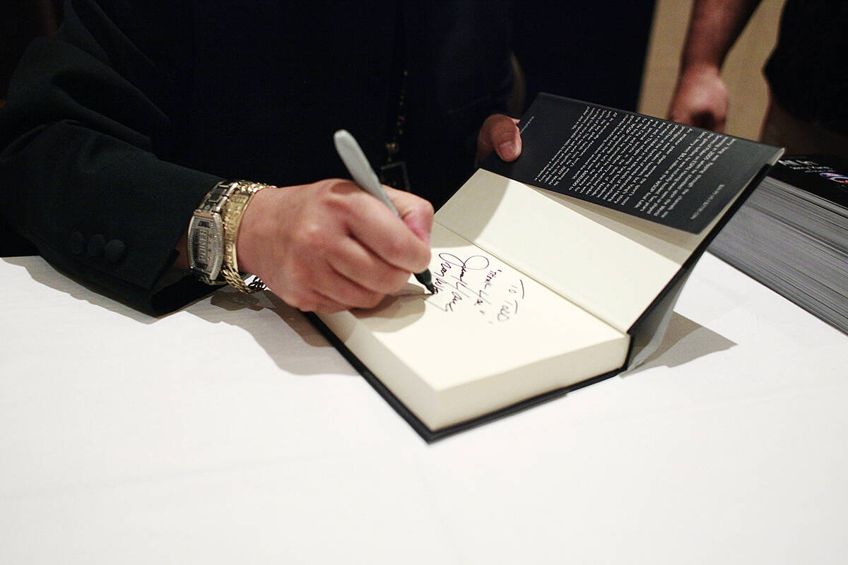 2007 World Series of Poker Main Event Champion Jerry Yang signs a book at his book signing for ...