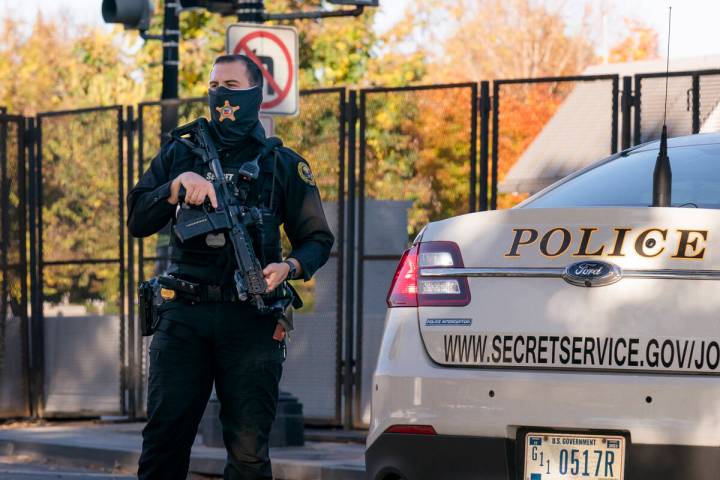 FILE - A U.S. Secret Service officer takes a position in the street as President Donald Trump's ...