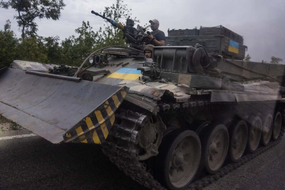 FILE - Ukrainian soldiers ride a tank on a road, in Stupochky, Donetsk region, eastern Ukraine, ...