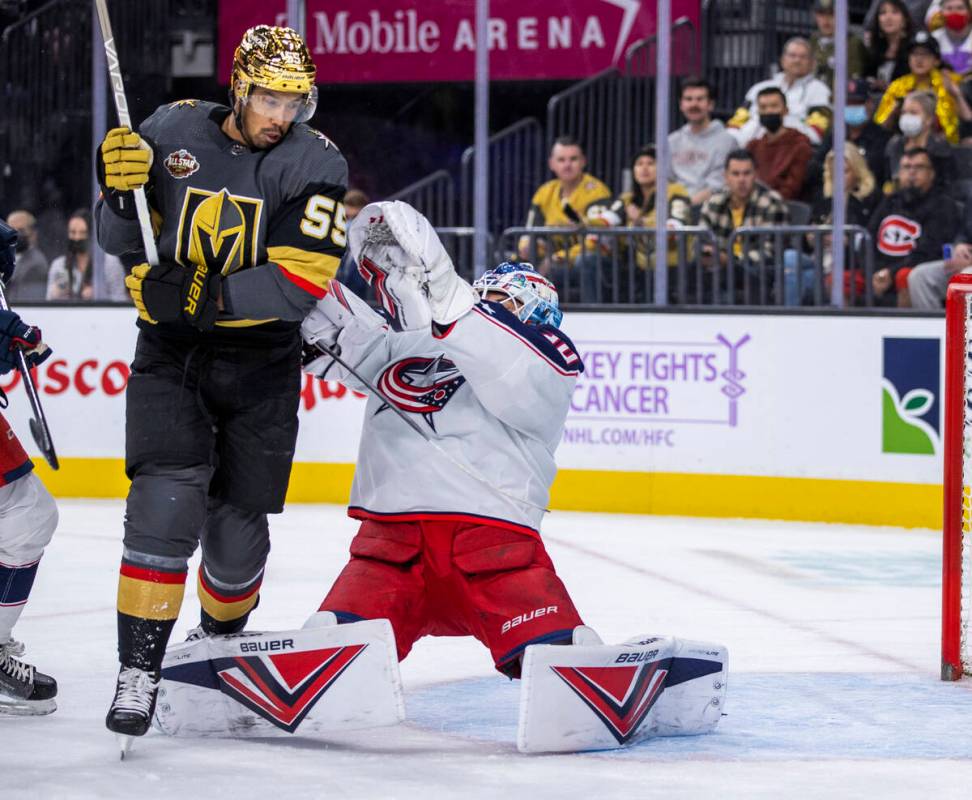 Golden Knights right wing Keegan Kolesar (55) tangles with Columbus Blue Jackets goaltender Elv ...