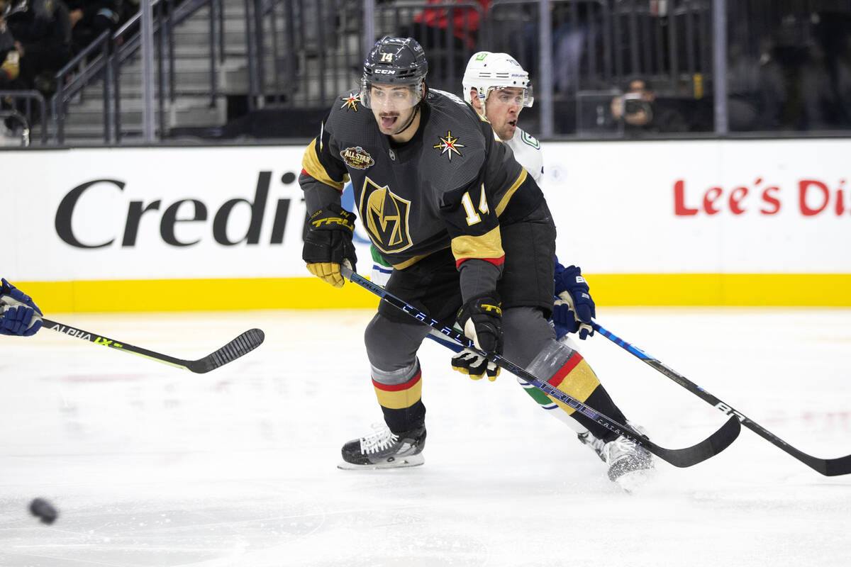 Golden Knights defenseman Nicolas Hague (14) anticipates the puck while Canucks left wing Tanne ...