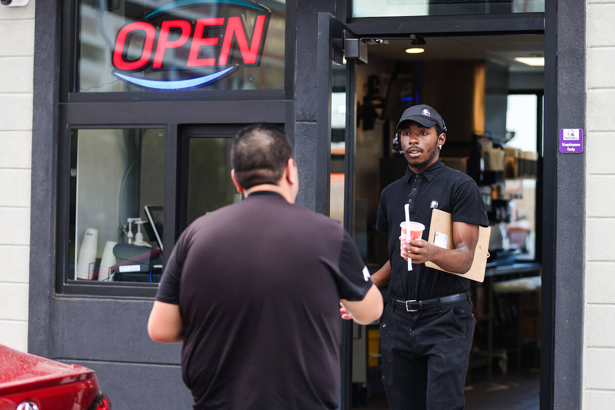 Employee Amanti Williams hands off drinks and food to a delivery food customer at a new &#x201c ...