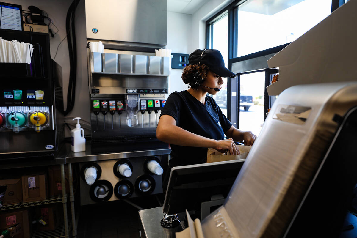 Employee Emmalise Reed prepares food for a customer at a new “Go Mobile” Taco Bel ...