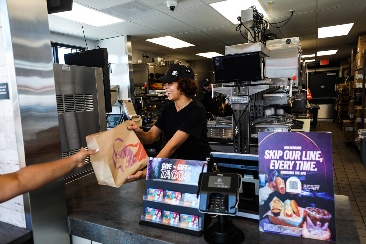 Employee Emmalise Reed hands off an order to a customer at a new “Go Mobile” Taco ...