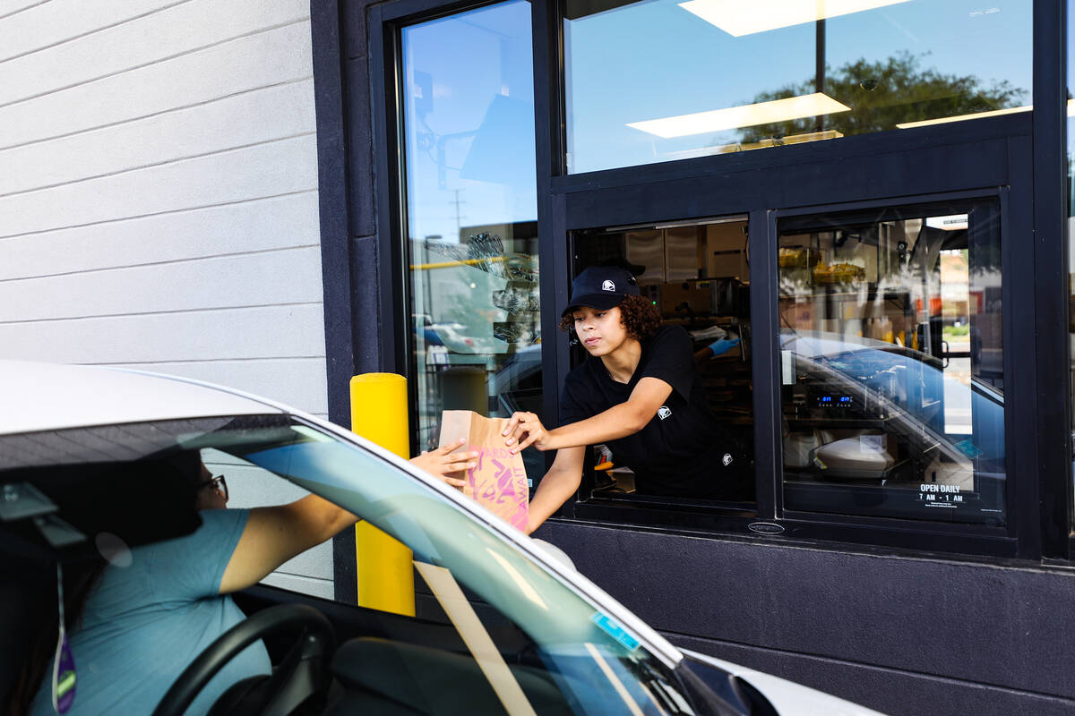 Employee Emmalise Reed hands off an order to a customer at a new “Go Mobile” Taco ...