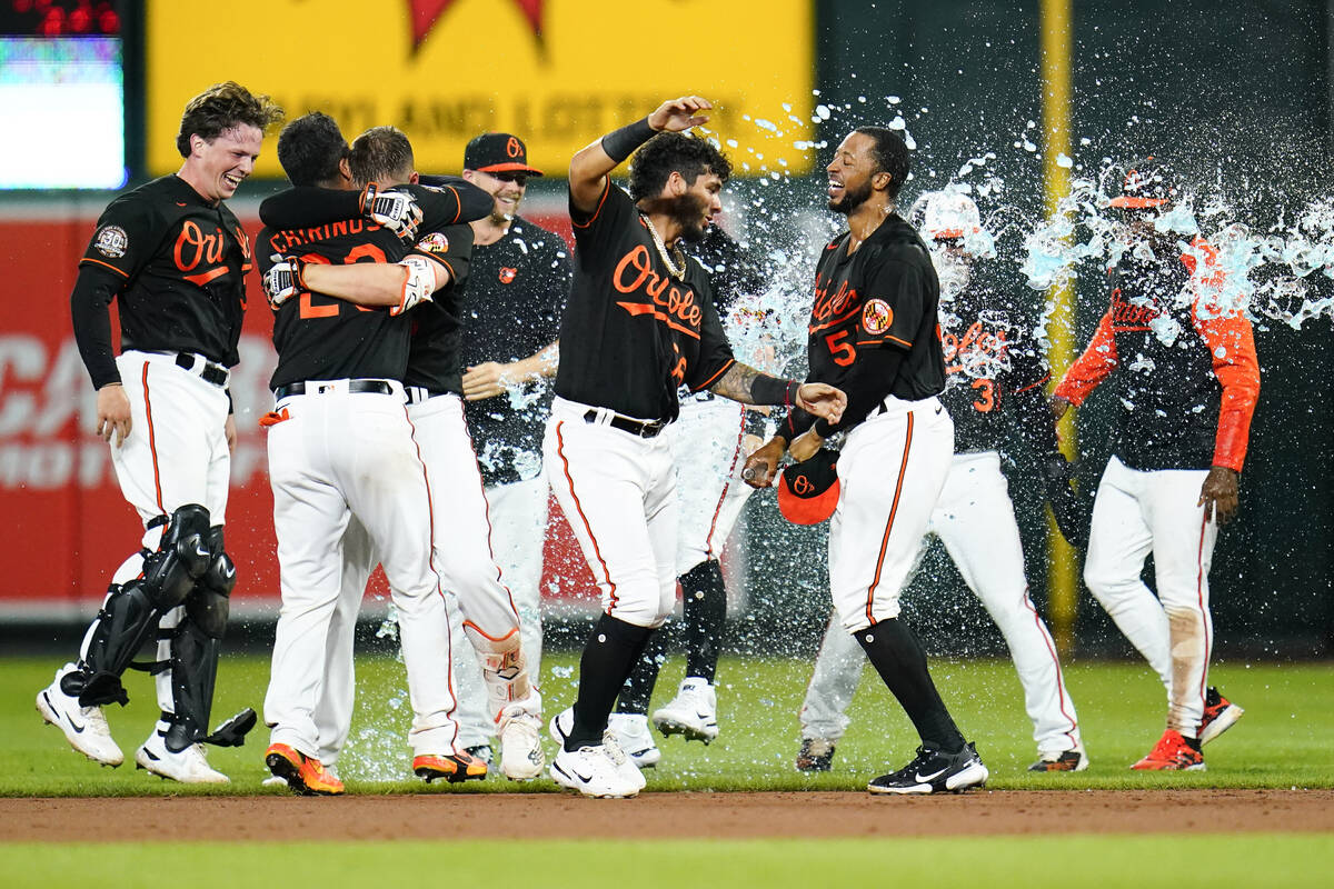 Baltimore Orioles players celebrate after designated hitter Trey Mancini hit a single to drive ...