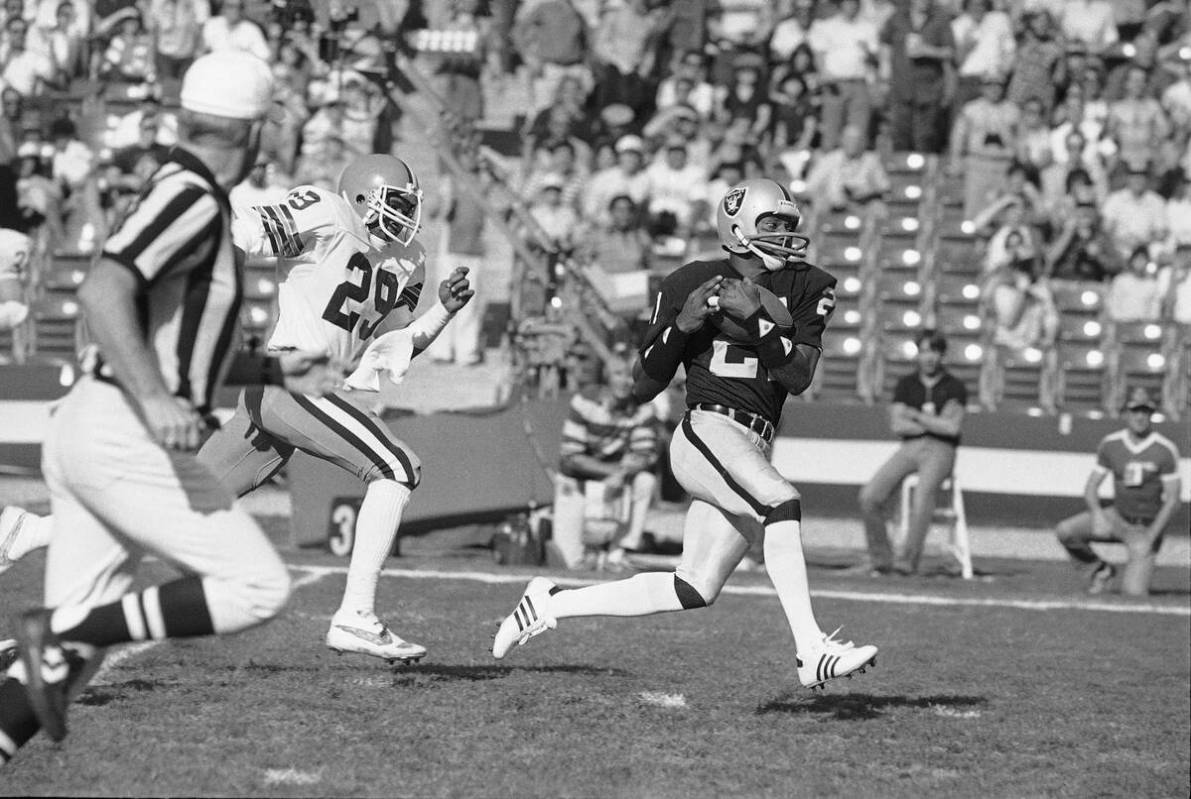 Los Angeles Raiders wide receiver Cliff Branch, right, catches a pass from quarterback Jim Plun ...