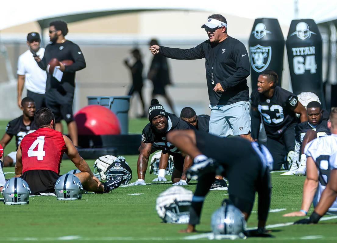 Raiders head coach Josh McDaniels laughs while talking with quarterback Derek Carr (4) during t ...