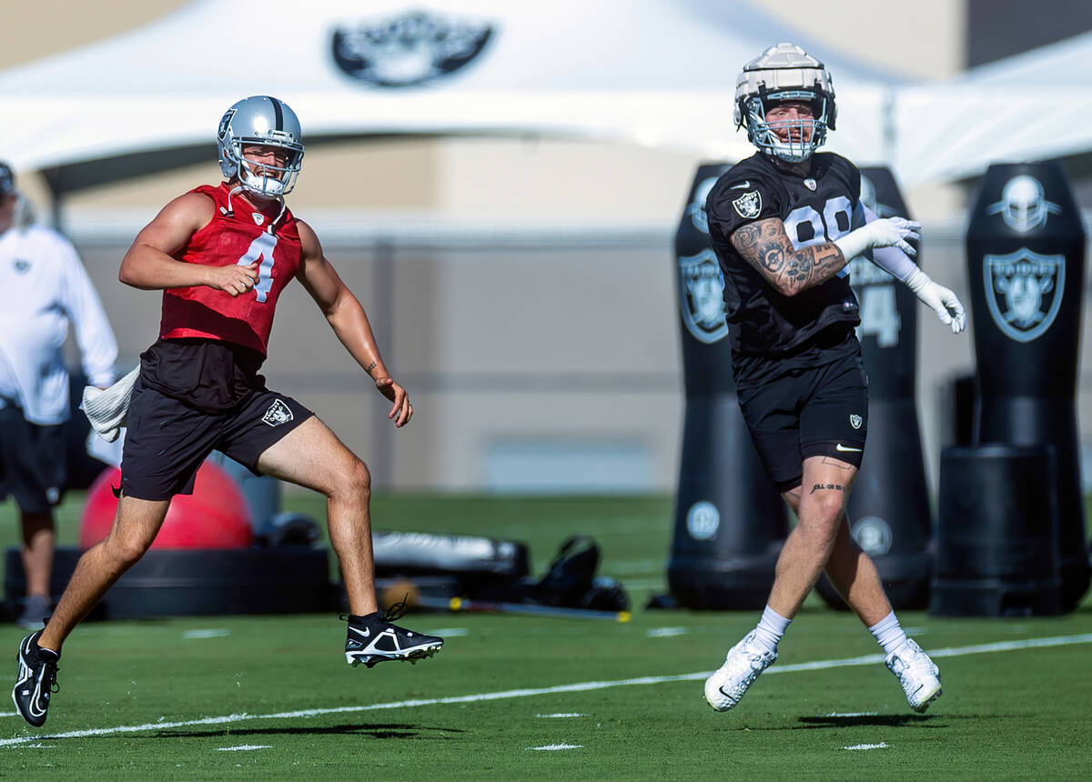 Quarterback Derek Carr (4) and defensive end Maxx Crosby (98) warm up during the Raiders first ...