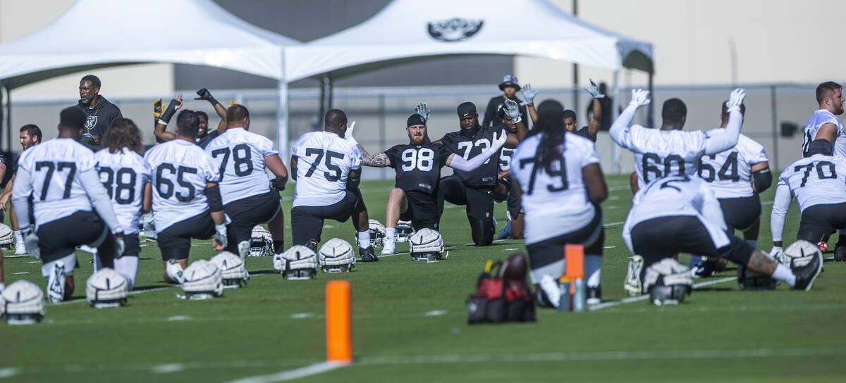 Players including defensive end Maxx Crosby (98) stretch during Raiders first practice at train ...