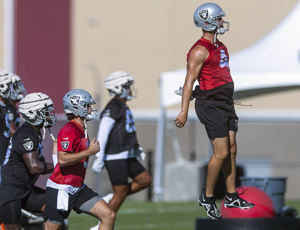 Quarterback Derek Carr (4) leaps in the air during warmups at the Raiders first practice at tra ...