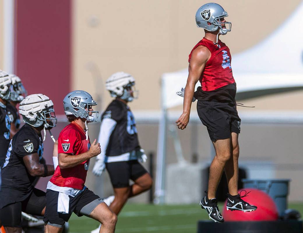 Quarterback Derek Carr (4) leaps in the air during warmups at the Raiders first practice at tra ...