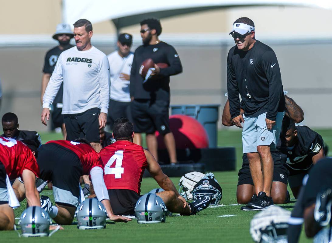 Raiders head coach Josh McDaniels laughs while talking with quarterback Derek Carr (4) during t ...