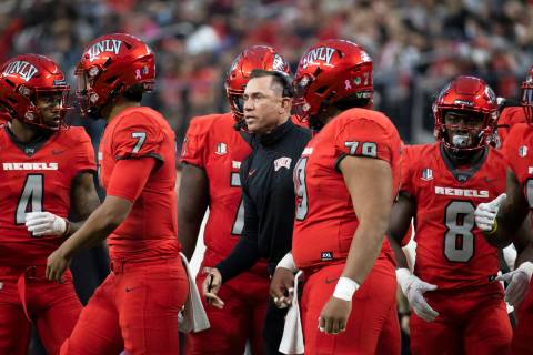 UNLV Rebels head coach Marcus Arroyo, middle, gives direction to his team during a time out in ...
