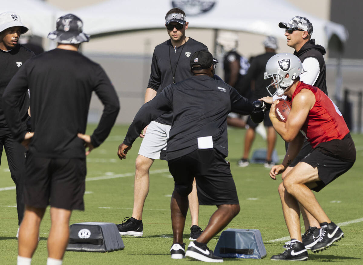 Raiders quarterback Derek Carr (4) runs through quarterback's drills as quarterbacks coach Bo H ...