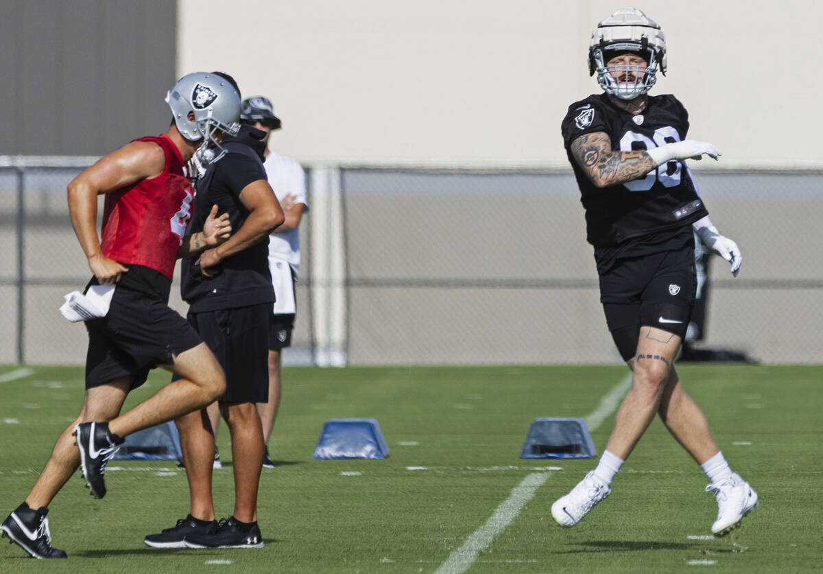 Raiders quarterback Derek Carr (4) and defensive end Max Crosby (98) run through drills during ...