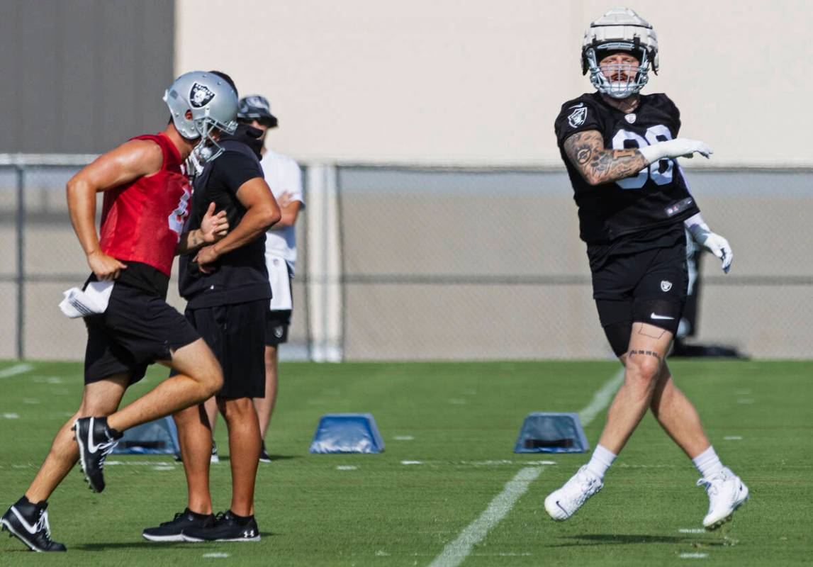 Raiders quarterback Derek Carr (4) and defensive end Max Crosby (98) run through drills during ...