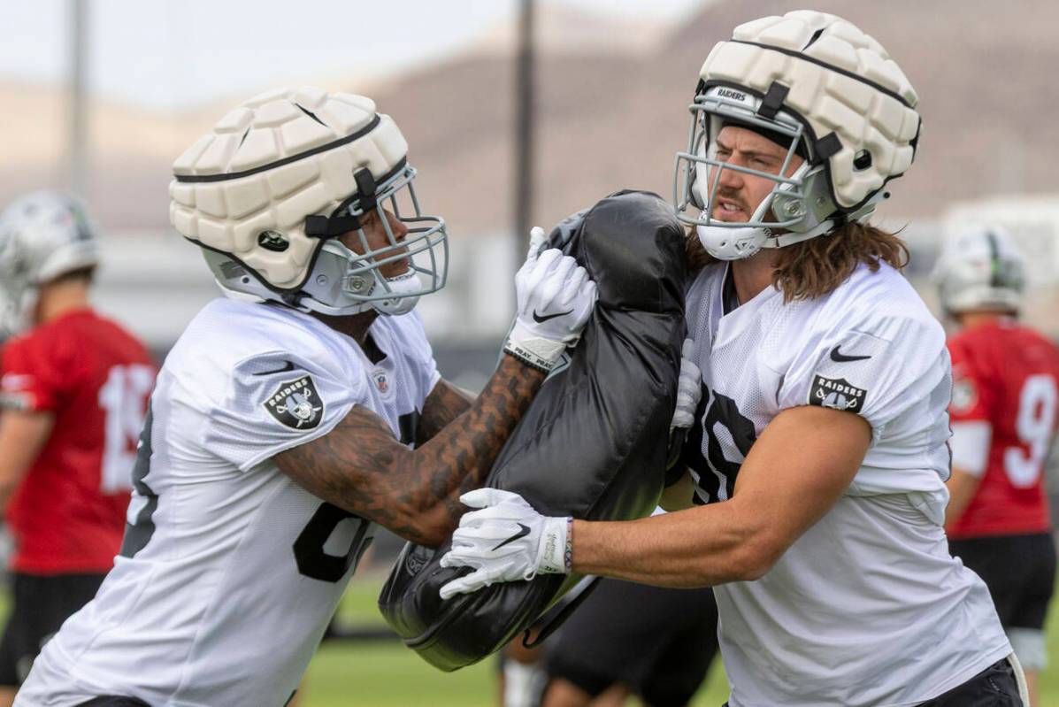 Raiders tight end Jacob Hollister (88), right, braces himself as tight end Darren Waller (83) m ...