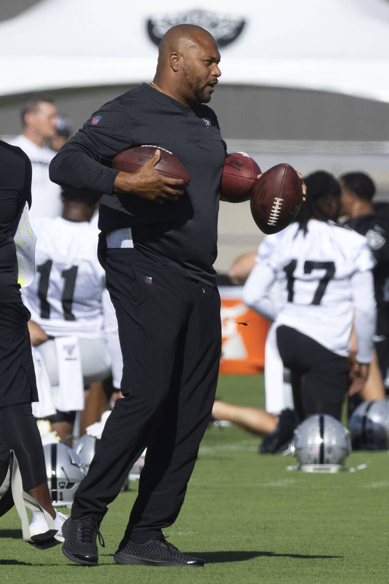 Raiders linebackers coach Antonio Pierce carries footballs to the sideline during the team&#x20 ...