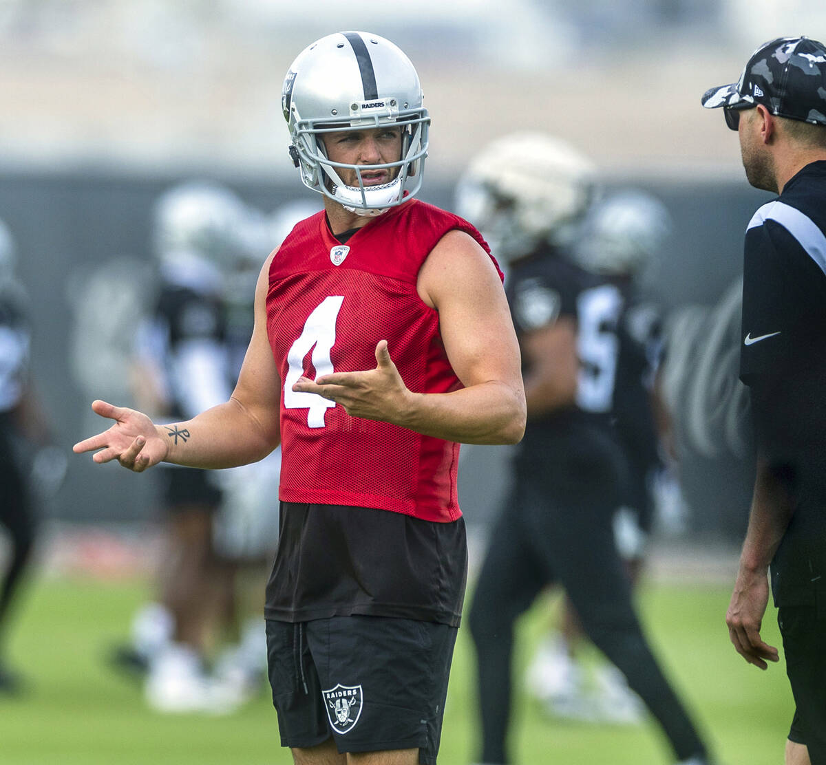 Raiders quarterback Derek Carr (4) confers with quarterbacks coach Bo Hardegree during training ...