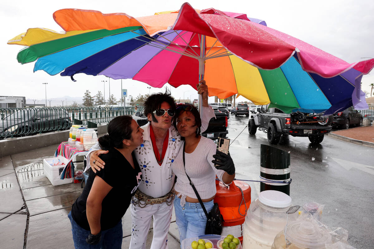 Yadi Hernandez, left, an Elvis busker who declined to give his name, and Abigail Telles Castill ...