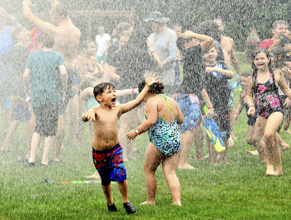 Water rains down on children during the Geneva Water Battle, Sunday, July 24, 2022, at Memorial ...