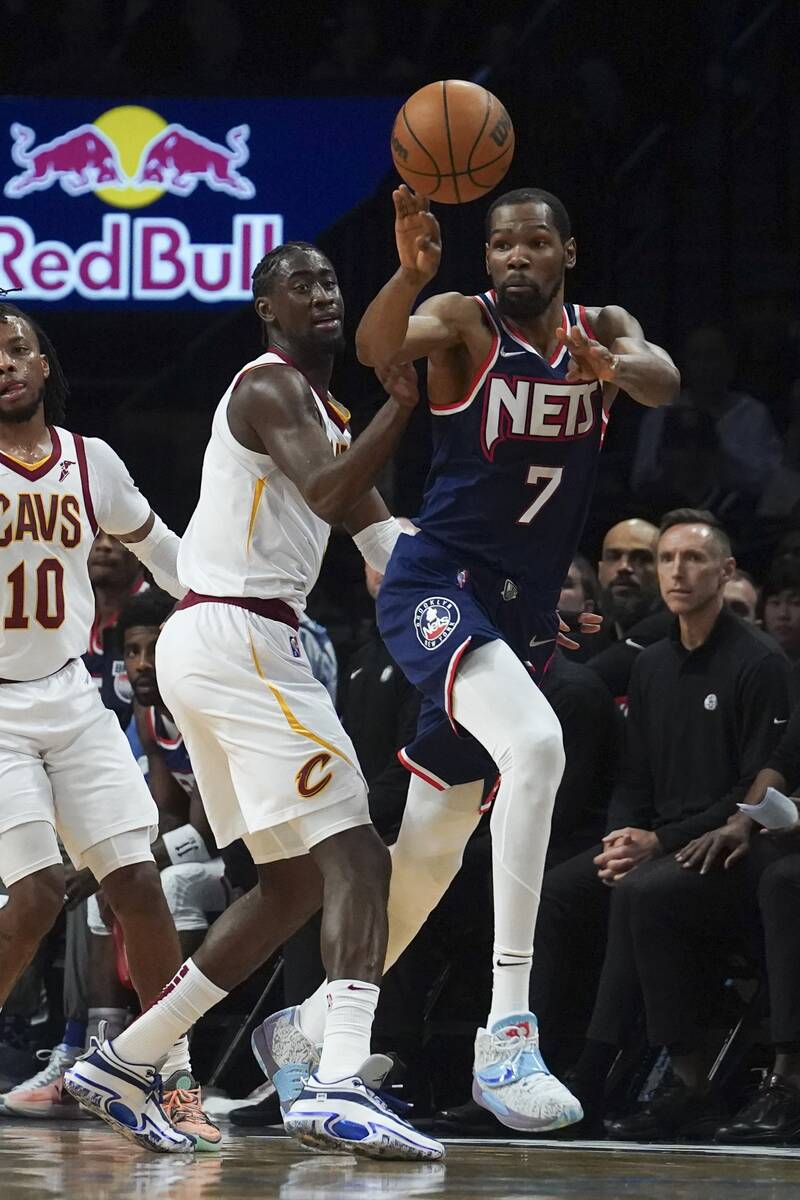Brooklyn Nets forward Kevin Durant (7) passes the ball around Cleveland Cavaliers guard Caris L ...