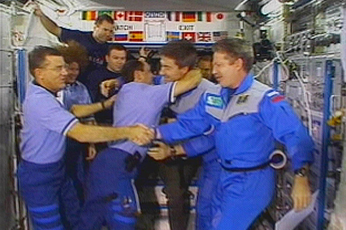 FILE - Astronaut James Voss, far left, shakes hands with astronaut Bill Shepherd, far right, as ...