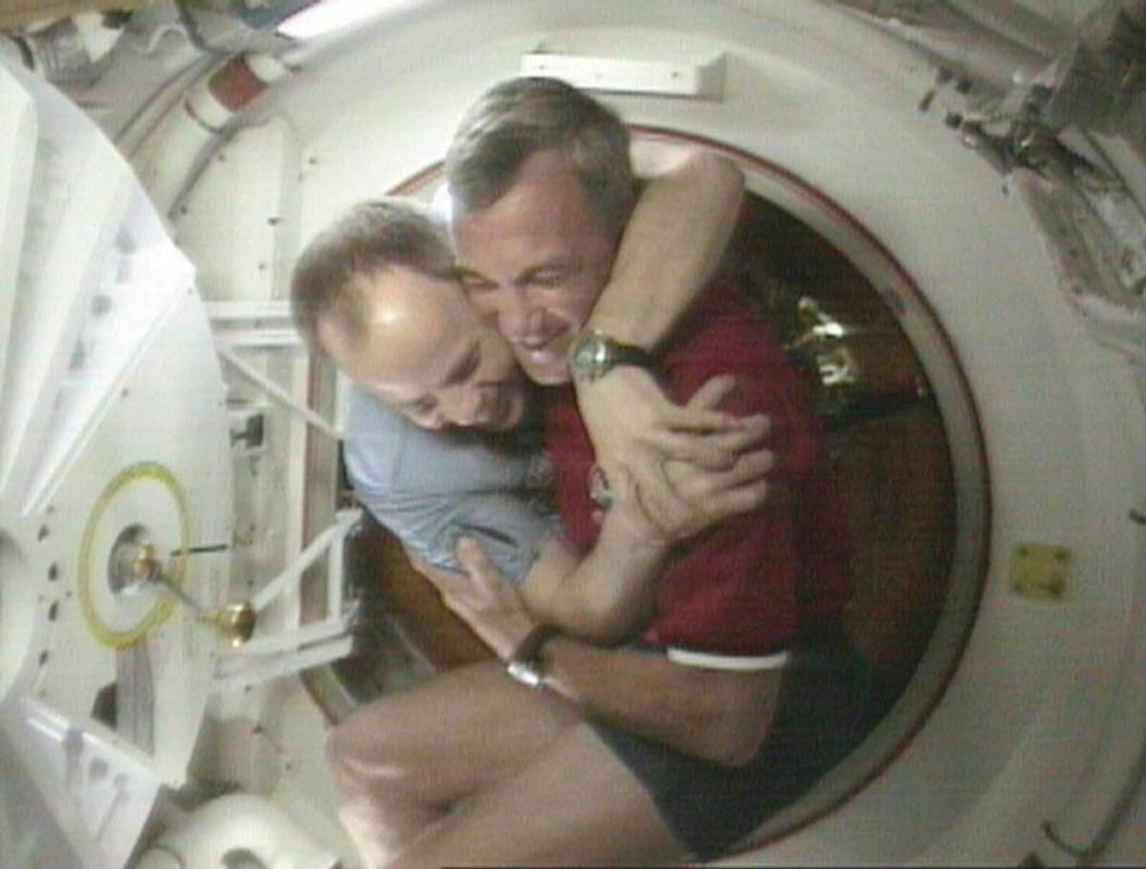 FILE - Shuttle Commander Terrence Wilcutt, right, and Mir Commander Anatoly Solovyev, left, hug ...