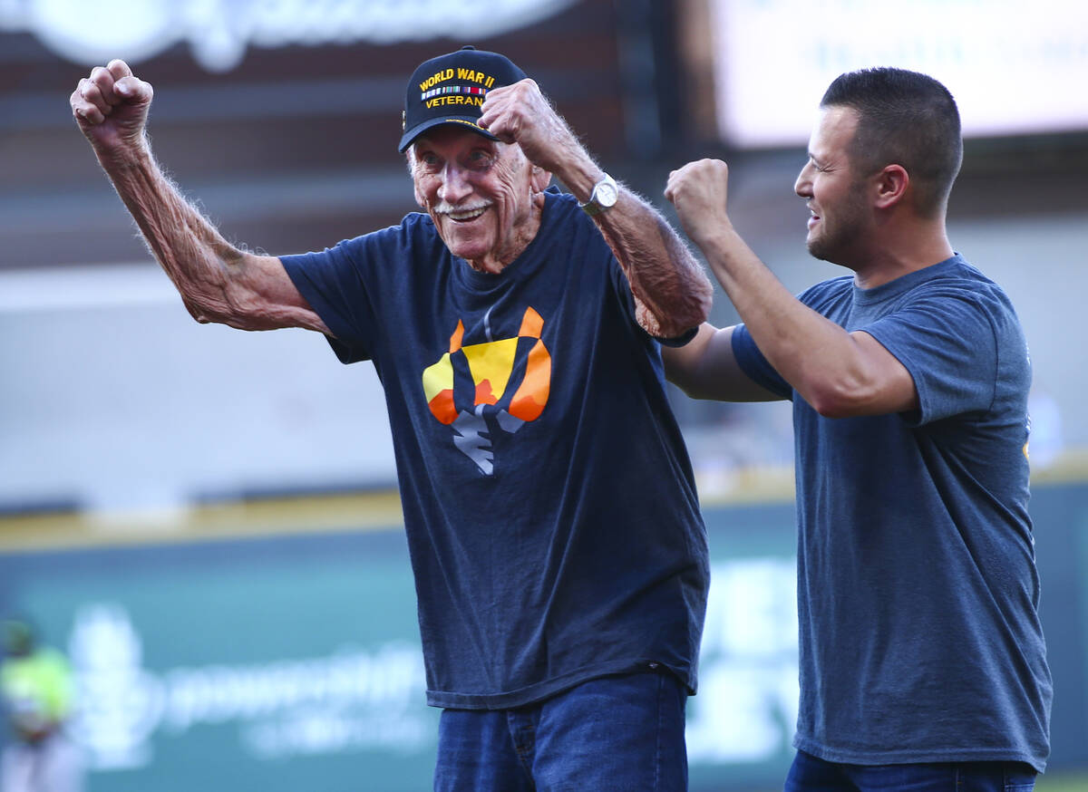 World War II veteran and former prisoner of war Dean Whitaker, 94, of Las Vegas, left, celebra ...