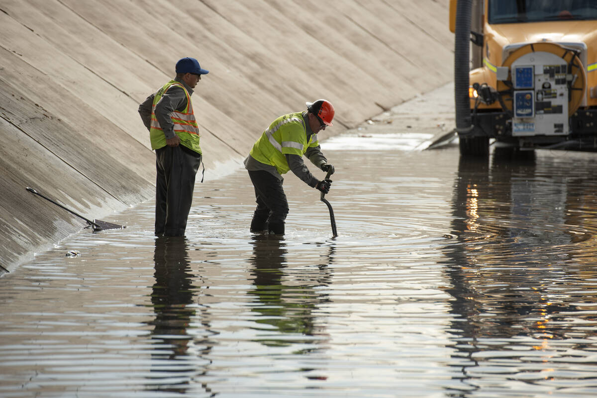 Nevada DOT workers work to clear floodwaters from West Washington Ave. near North Main St. on F ...