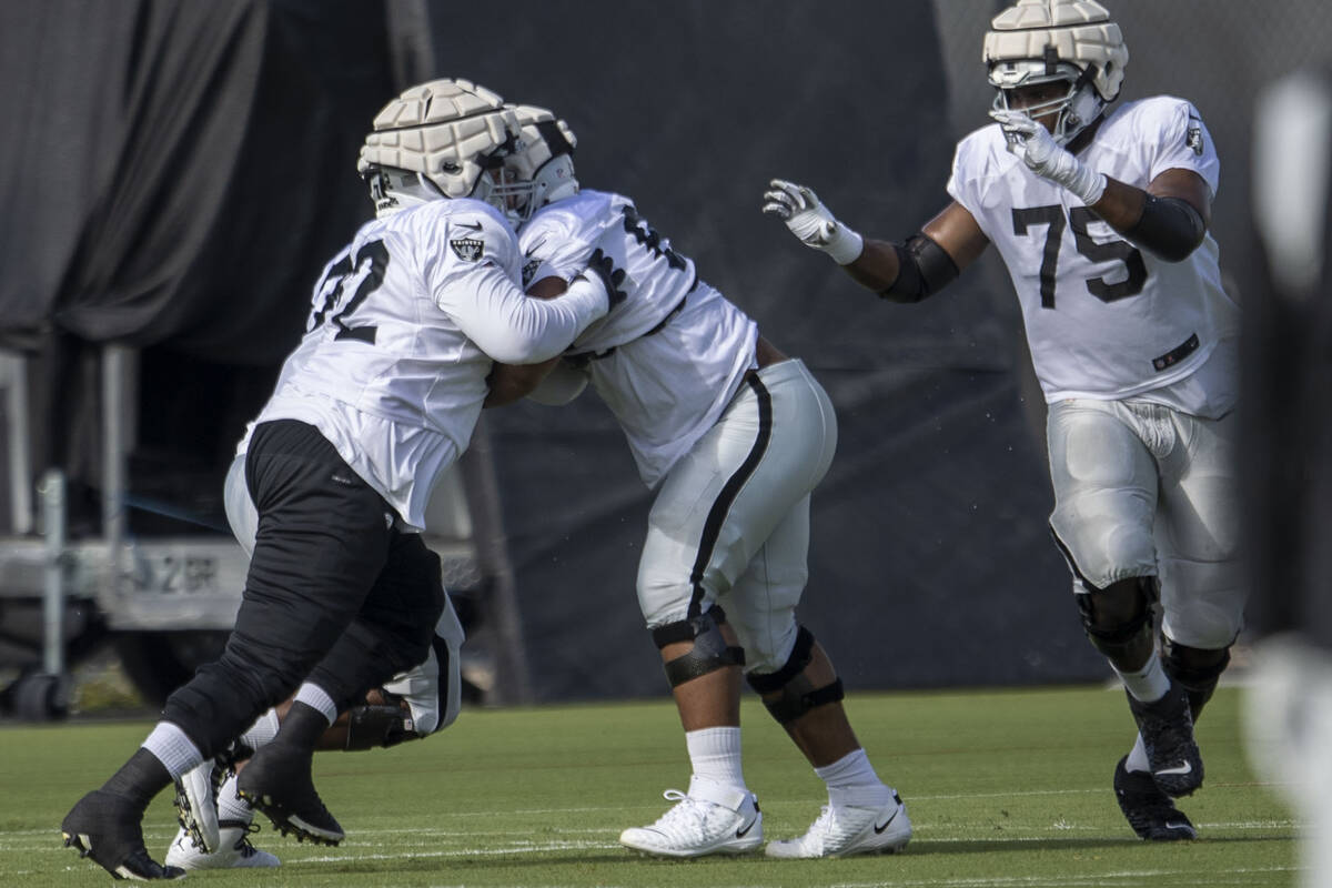 Raiders offensive linemen Jermaine Eluemunor (72) and Dylan Parham (66) work against each other ...