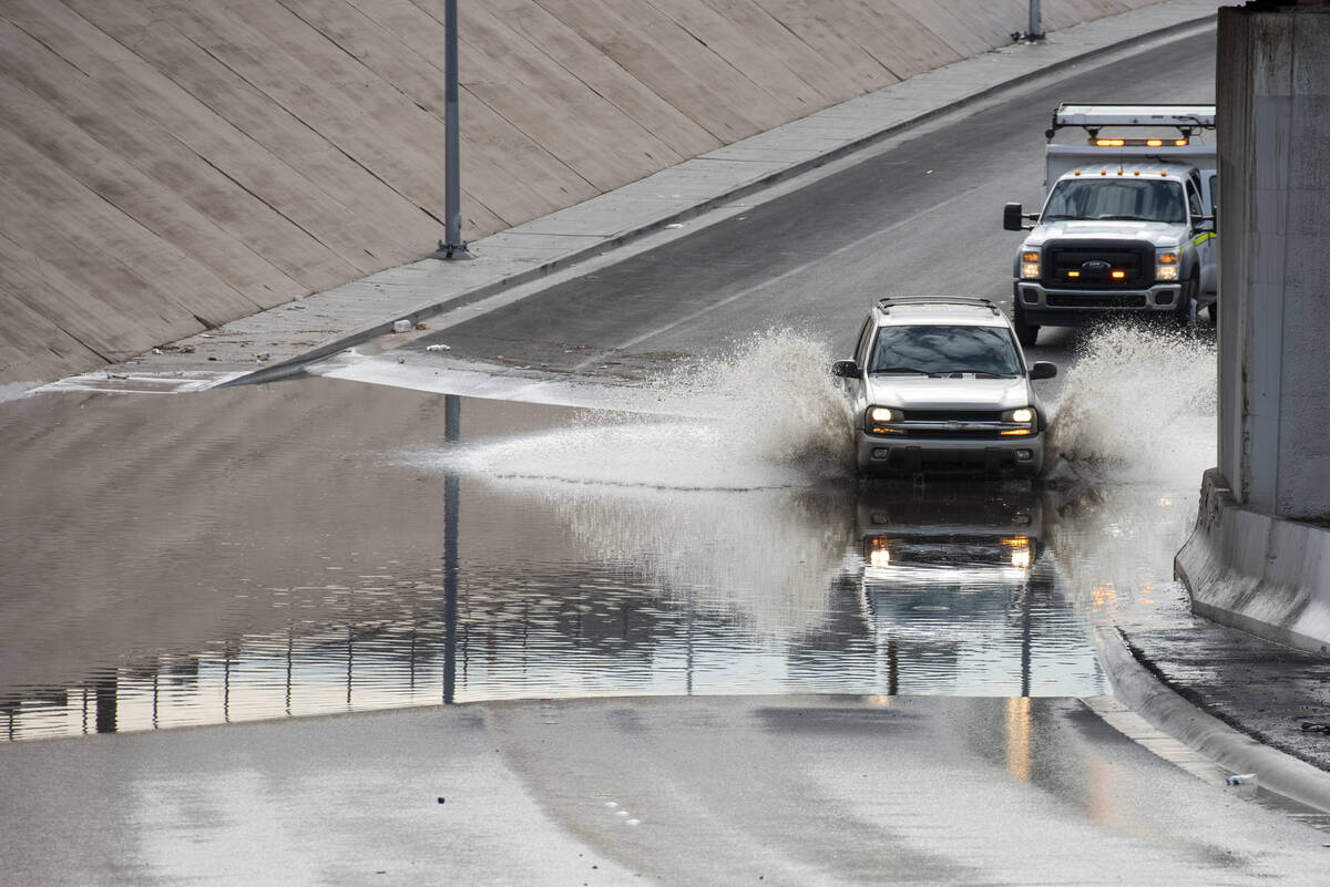 A car drives though flood waters on West Washington Avenue near North Main Street on Friday, Ju ...