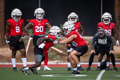 UNLV's Cortney Reese (26), left, and Andrew Wimmer (28), run a drill during a team football pra ...