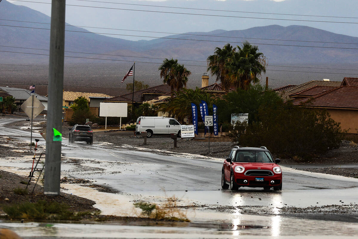 A car drives over a washed out road from monsoonal flash floods in Pahrump, Nev., Sunday, July ...