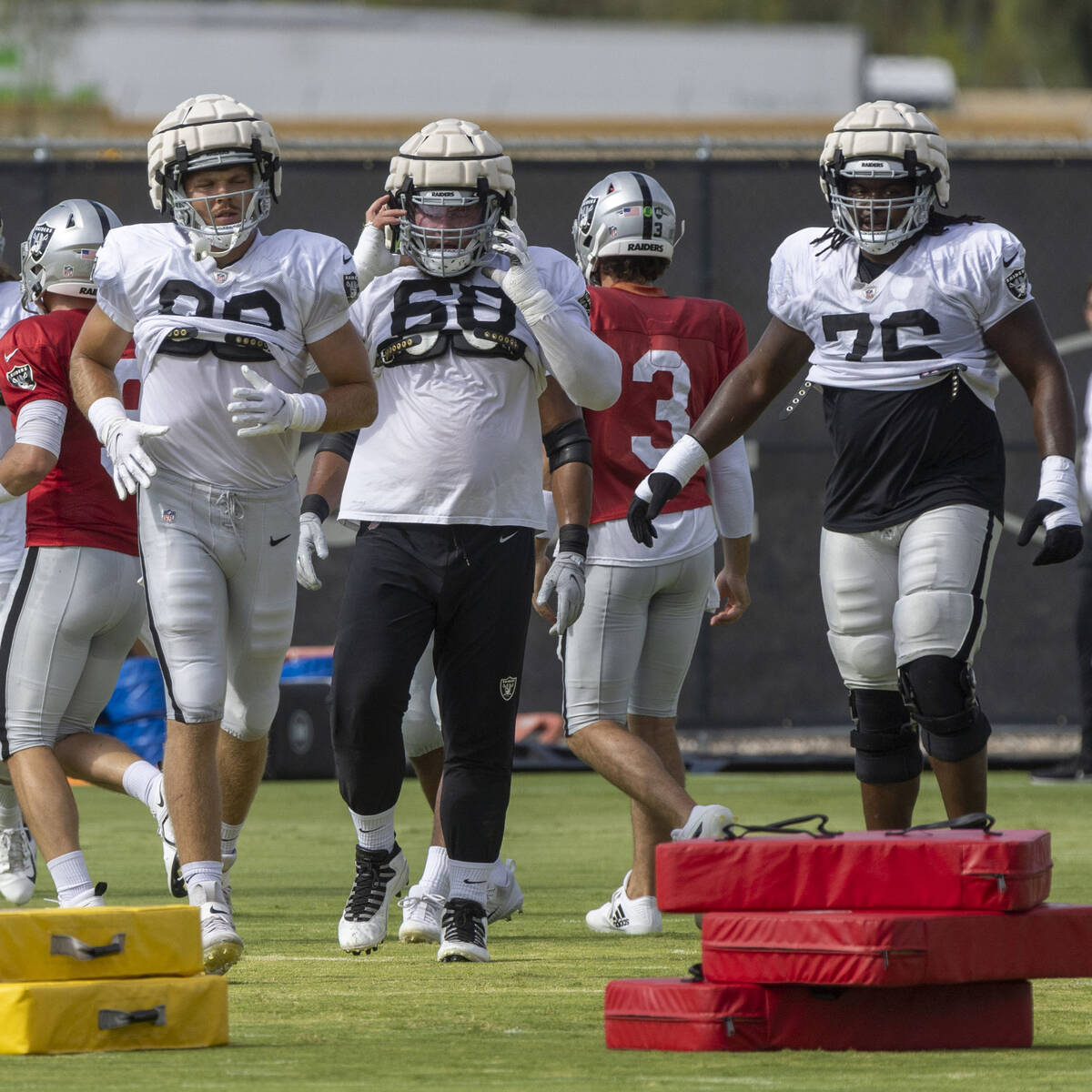 Raiders tight end Nick Bowers (82), center Andre James (68) and offensive guard John Simpson (7 ...