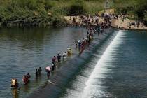 Haitian migrants use a dam to cross into the United States from Mexico in Del Rio, Texas, in 20 ...